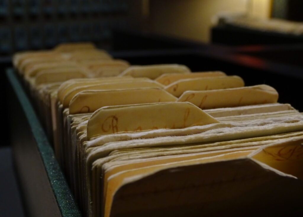 Rows of old file folders in a dimly lit archive room, representing content nobody ever navigates to