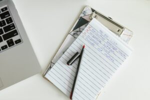 A to-do list on a clipboard beside a laptop and pen, representing a pre-deployment checklist