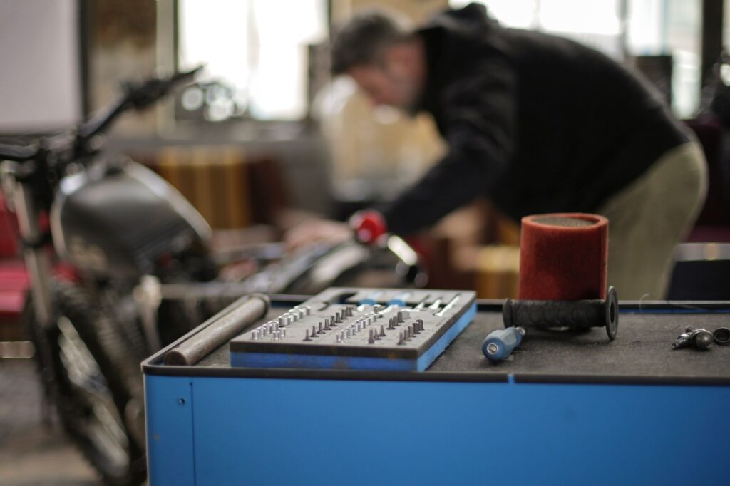 An open toolbox with metal parts on a workbench in a workshop
