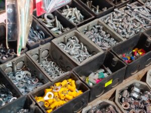 Hardware fasteners sorted into separate storage bins by type, nuts, bolts and washers